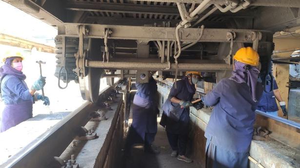 Pink team performs arduous rail coach maintenance work