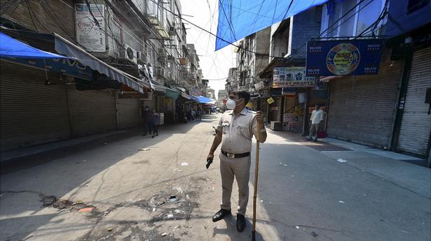 A policeman stands guard at Gaffar Market in New Delhi on July 10, 2021 after the market was closed for 48 hours for flouting COVID-19 norms.