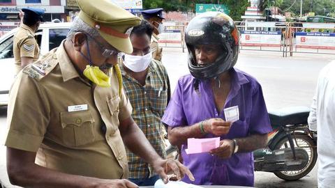 A motorcyclist being slapped spot fine for not wearing mask, near Tamukkam Ground in Madurai on Monday. 