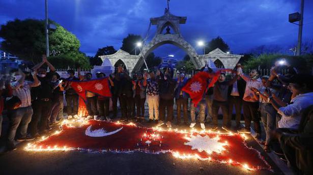 People light candle on an outline of the new map of Nepal drawn on a road in Kathmandu