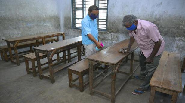   Workers clean a classroom of a government school which will be reopened with limited students on October 8, in Puducherry on October 5, 2020.  