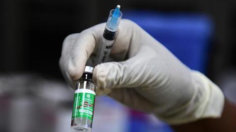   A medical worker holds a vial of the Covishield vaccine at Moti Lal Nehru Medical College in Allahabad on April 1, 2021. 